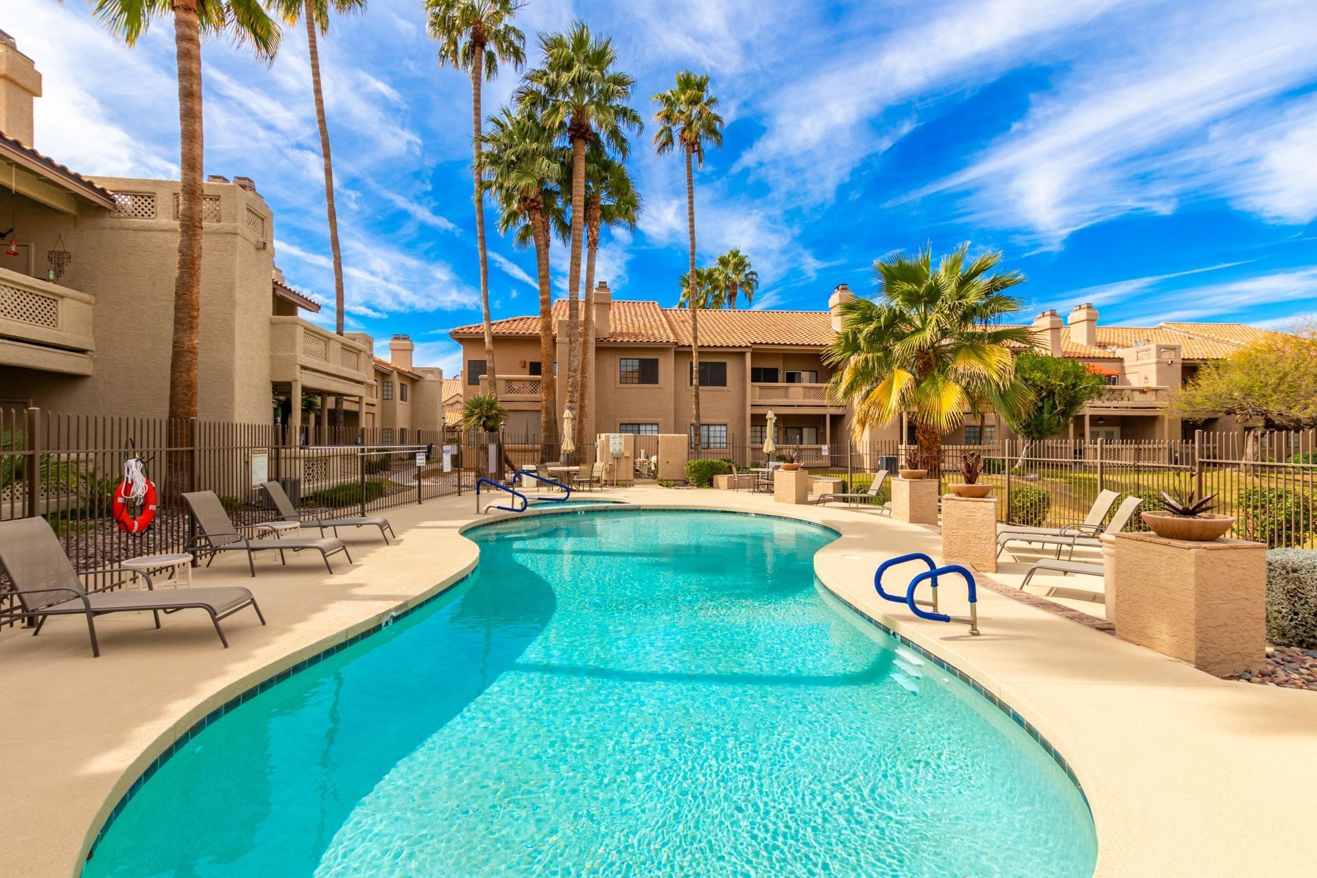 Community pool surrounded by palm trees