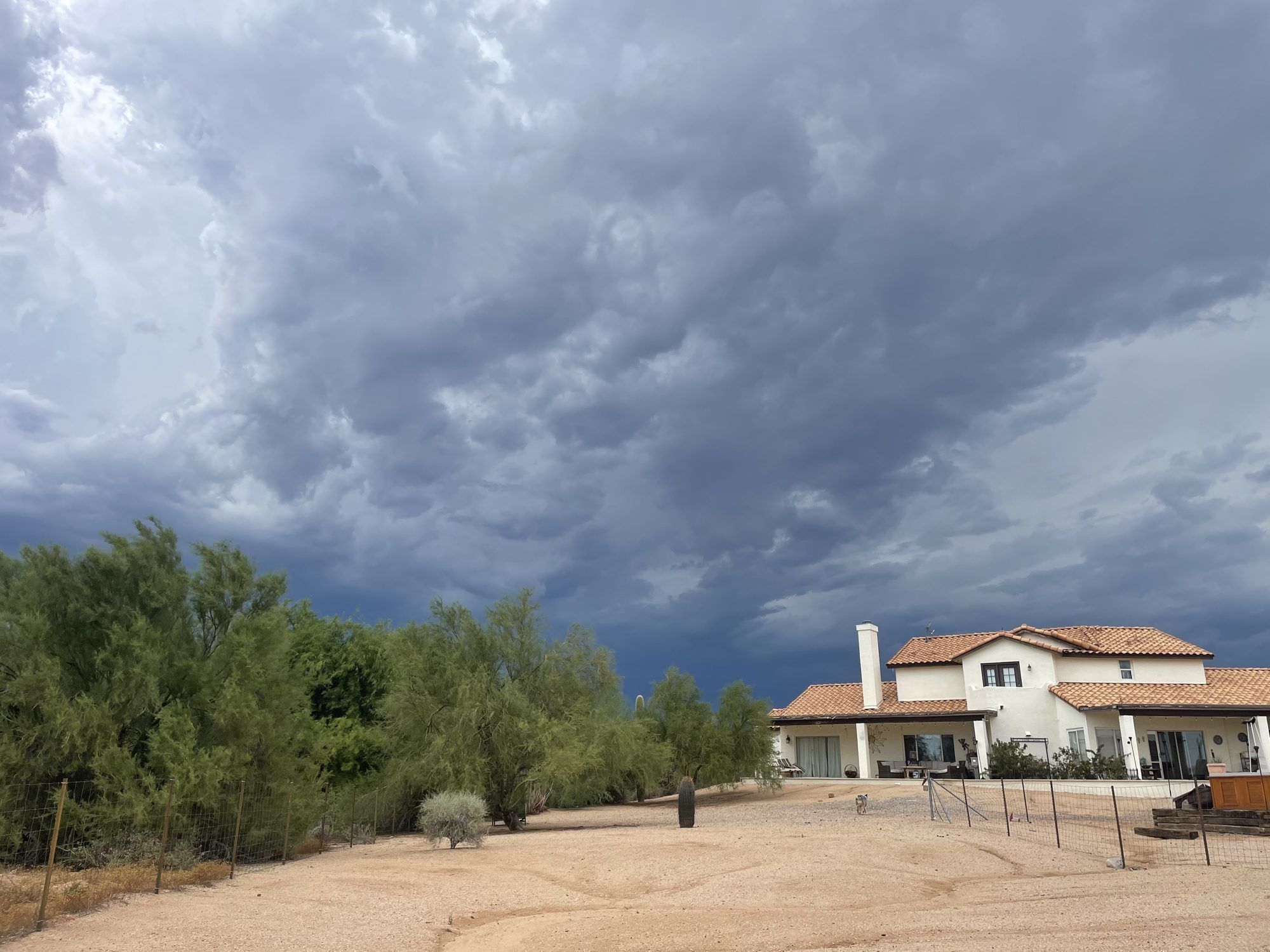 Monsoon clouds building over a home in the Arizona desert