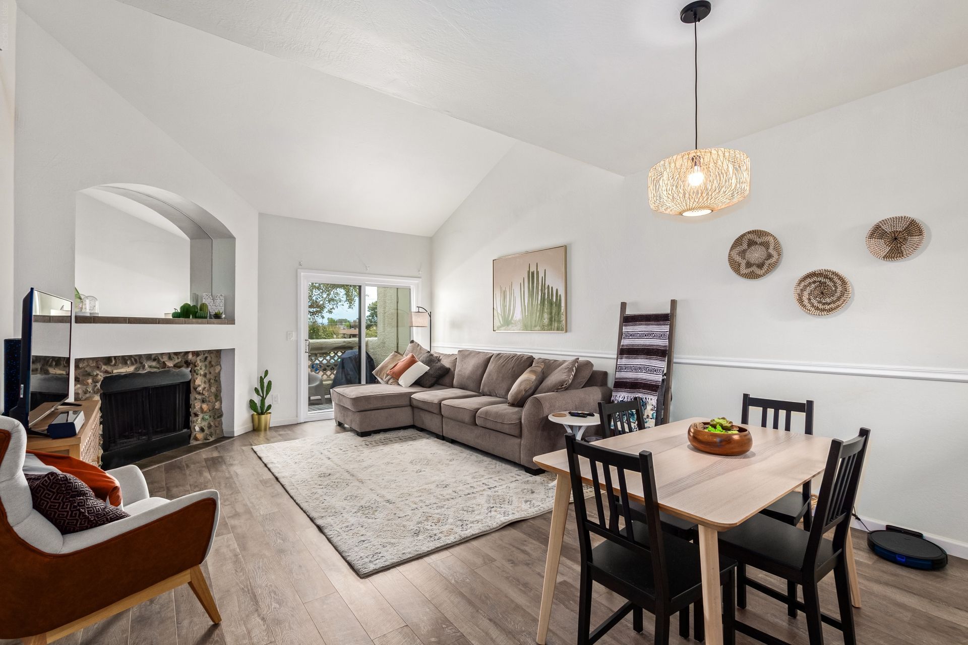Bright condo living room with a fireplace and vaulted ceiling